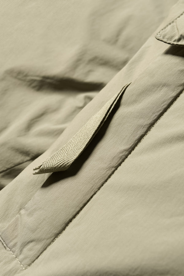 Close up zip and fabric detail shot of the  Men’s Prospect Down Puffa a technical jacket with removable hood and utility pockets, made from recycled nylon. In Dusty Olive Green 