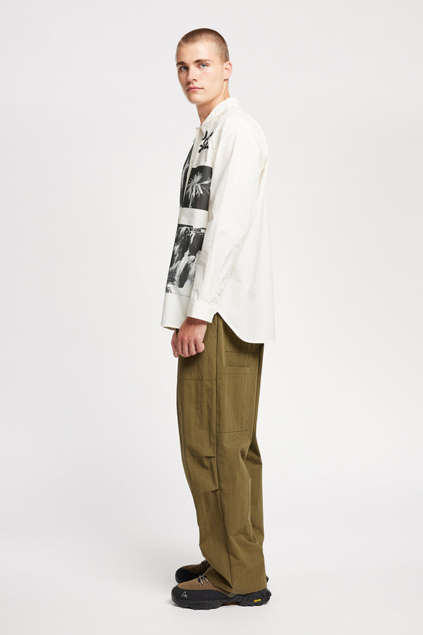 Side of Model wearing the Rame shirt, an off-white printed shirt with relaxed fit, structured collar, and vintage-photo placement print.