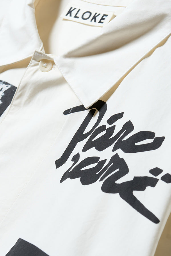 Close-up detail shot of the shirt collar and “panorame” text on off-white cotton fabric.