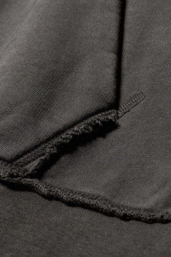 Close-up of raw flatlocked seams and blind-stitched finish on heavyweight unbrushed fleece on the Relic Hoodie in Jet Black