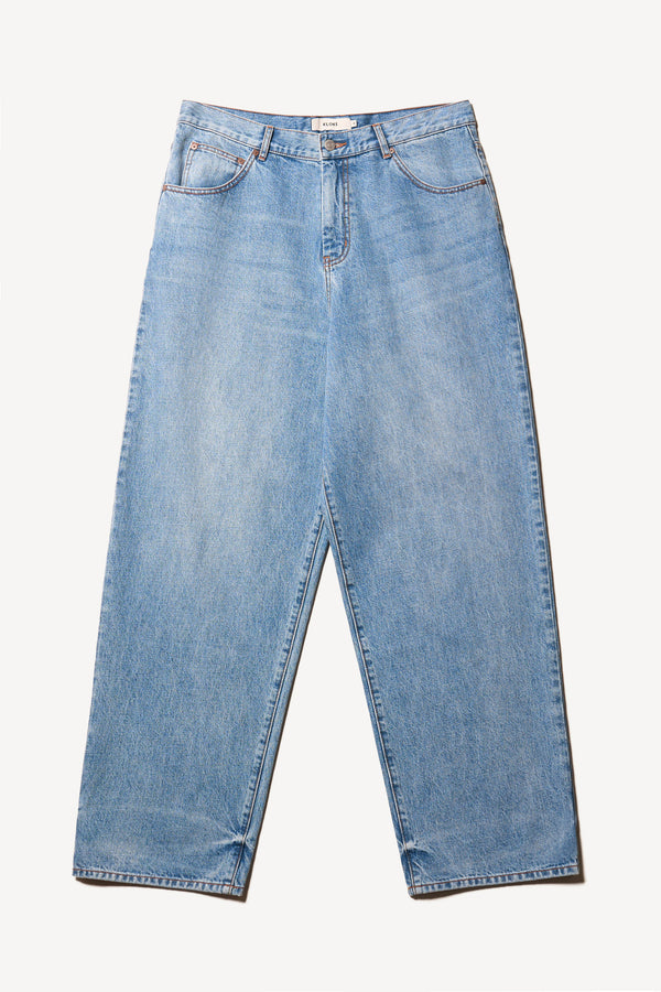 Flat front of the renew jean, a relaxed loose-fit straight style in premium Japanese denim, shown in mid-blue fade with five-pocket design and custom branded hardware.
