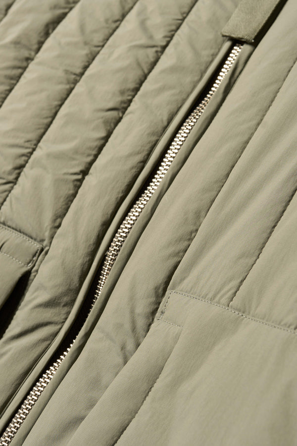 Close up zip detail shot of the response quilted military field jacket with structured collar and concealed zip in dusty olive green