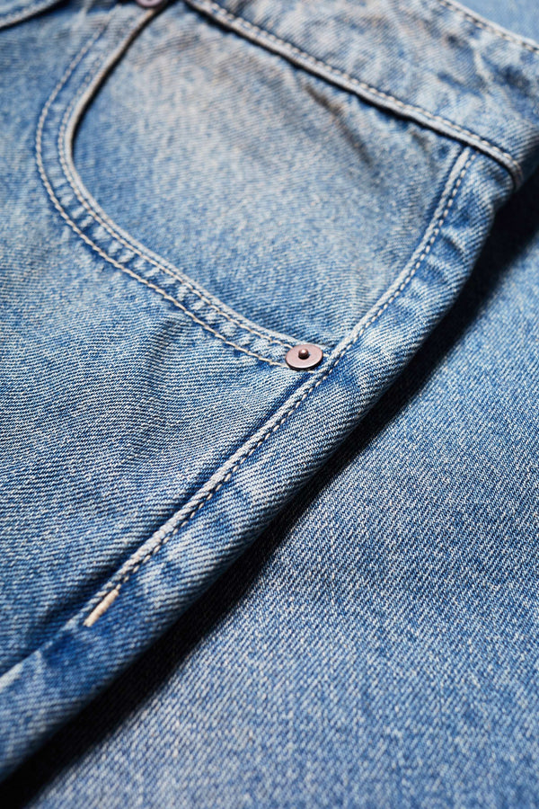 Close up pocket details of The sworn denim jean in Mid Blue Fade. Looser fit all-purpose jeans in premium Japanese denim with zip fly, button closure, five-pocket design, and Kloke branded hardware. Available in 8 sizes.