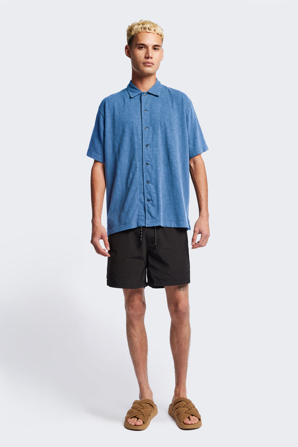 The Tectonic Shirt in blue, a classic boxy fit T-Shirt made from 100% cotton garment dyed jersey with a reinforced back yoke. Available in 5 sizes. 