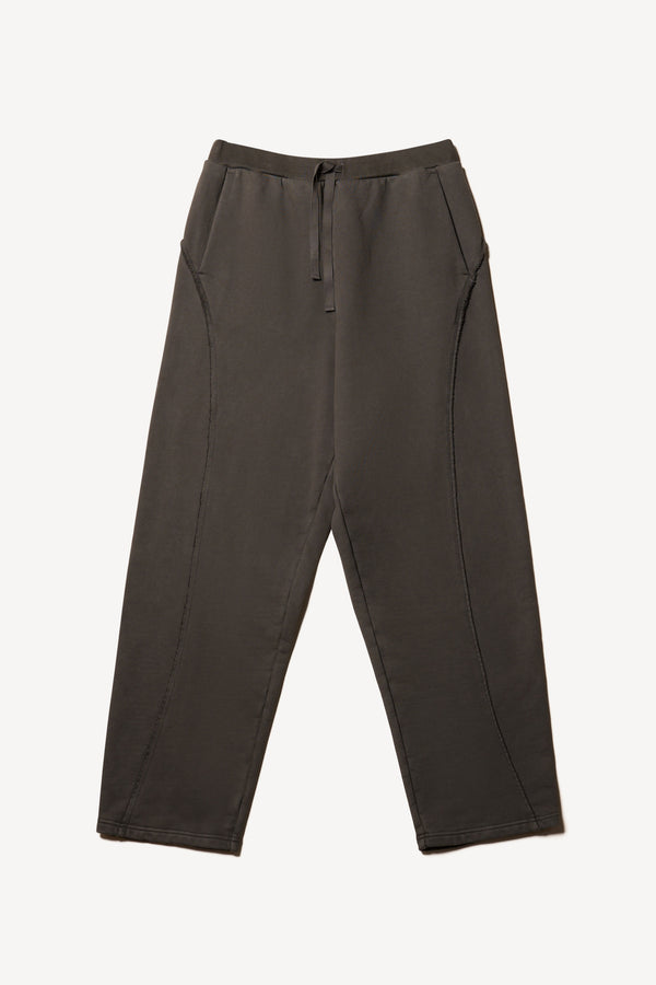 Flat Front of relaxed tapered fleece pants in Black pigment-dyed cotton with curved seam detailing and elastic waistband