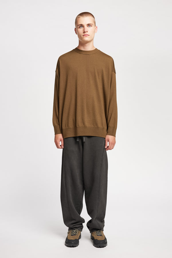 Front of Model wearing relaxed tapered fleece pants in Black pigment-dyed cotton with curved seam detailing and elastic waistband