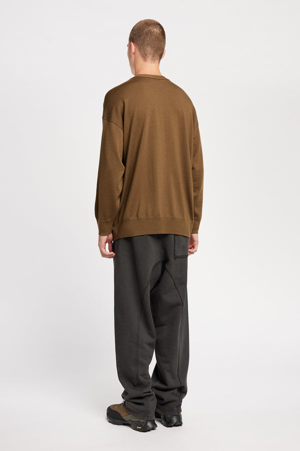 Back of Model wearing relaxed tapered fleece pants in Black pigment-dyed cotton with curved seam detailing and elastic waistband
