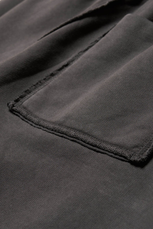 Close up fabric shot of Black pigment-dyed cotton with curved raw flatlock seam detailing