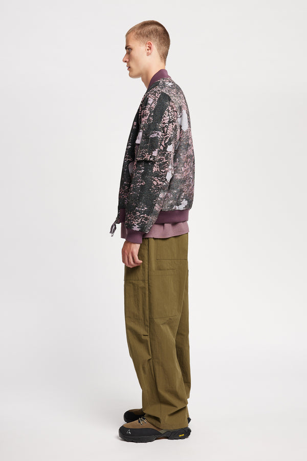 Men - Side of Unisex bomber jacket in Purple Print woven jacquard with real tree camouflage, featuring dropped shoulders, ribbed trims, and full-length front zip.