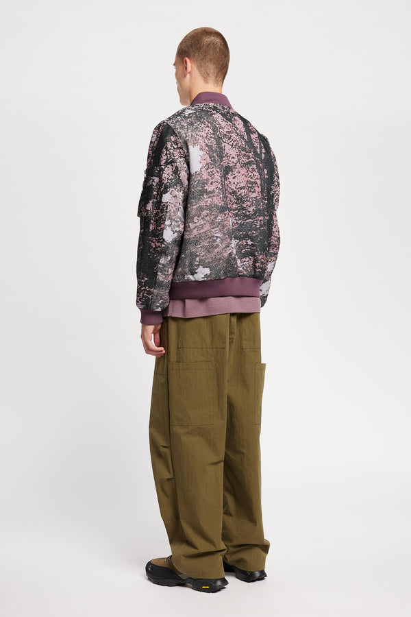 Men - Back of Unisex bomber jacket in Purple Print woven jacquard with real tree camouflage, featuring dropped shoulders, ribbed trims, and full-length front zip.