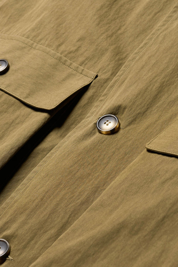 Close up fabric and pocket detail shot of the Venture Trench in kelp green,  an oversized fit in cotton-nylon with structured collar and flap pockets