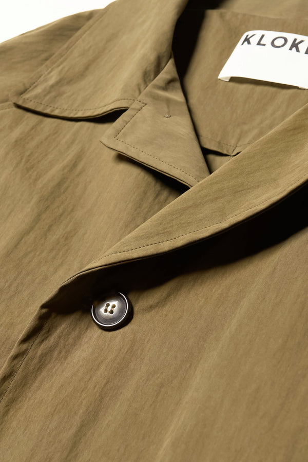 Close up collar detail shot of the Venture Trench in kelp green,  an oversized fit in cotton-nylon with structured collar and flap pockets
