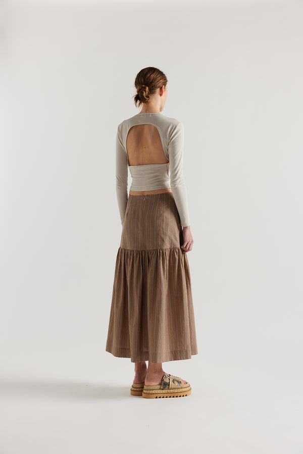Back of Model in Clay Stripe Panelled cotton skirt with gathered full silhouette, wide yoke waist, and invisible back zip closure.