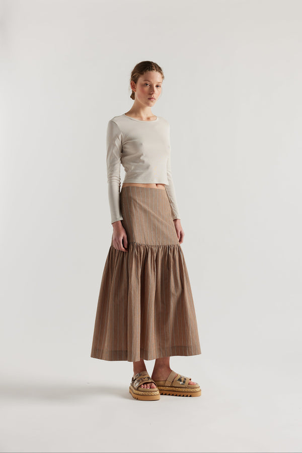 Front of Model in Clay Stripe Panelled cotton skirt with gathered full silhouette, wide yoke waist, and invisible back zip closure.