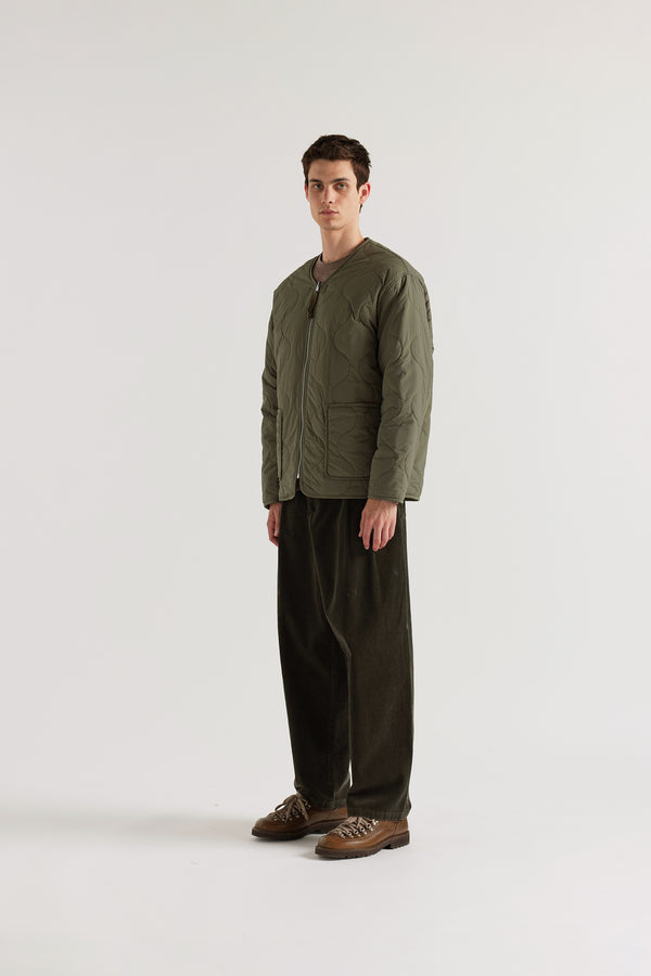 Front angle of the Olive Solstice Reversible recycled nylon jacket shown with ripple-patterned stitching facing outward and front pockets visible
