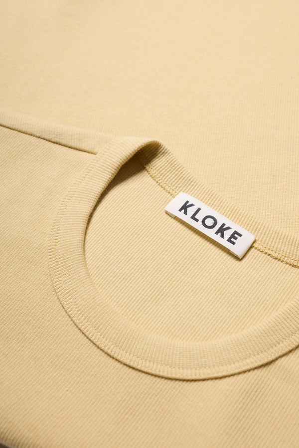 Fabric texture detail of Japanese-milled ribbed cotton ringer tee in pale yellow. 