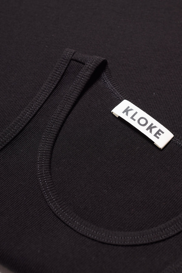 Detail close up of the Wing tank in Black. A slim-fit ribbed cotton tank with a slight racer neckline. A clean, minimal silhouette