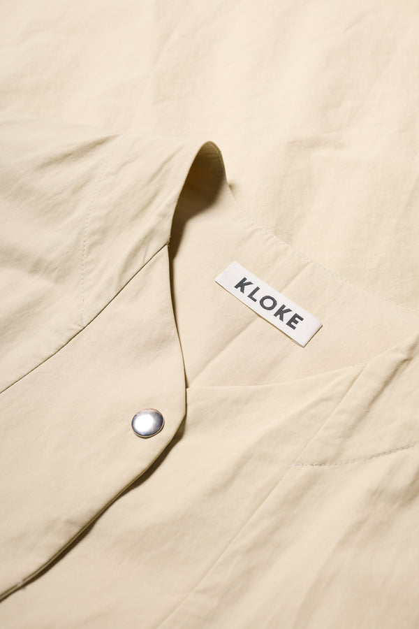 Detail of the Stone Locate Jacket’s rounded neckline and button detail. 