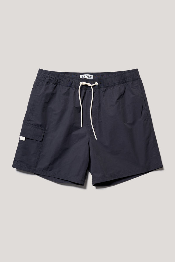 flat front shot of relaxed fit swim shorts in black with an elastic drawstring waist and functional pocket detailing.
