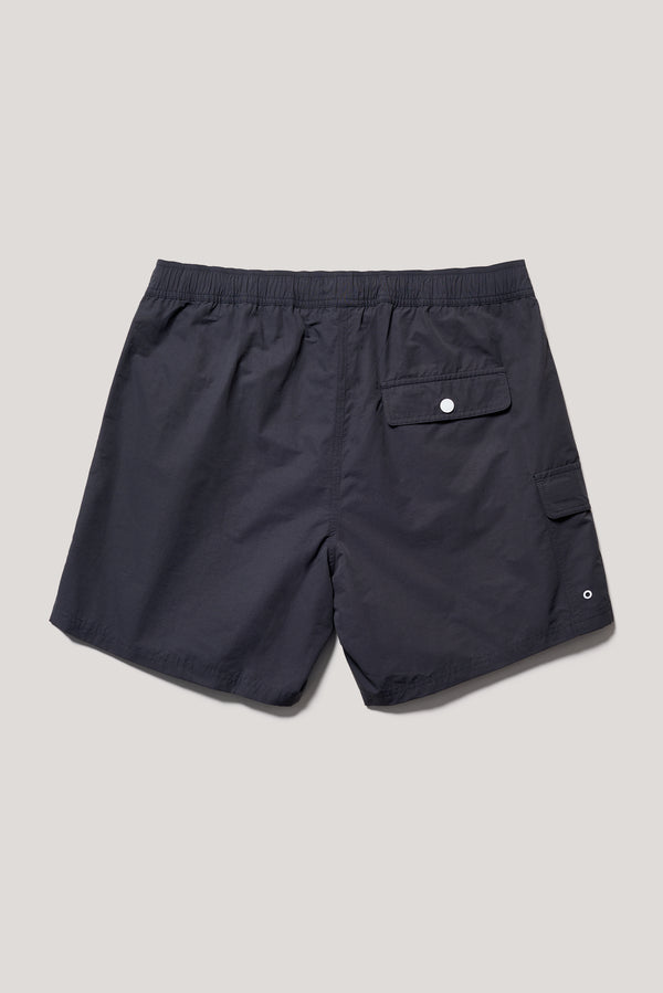 flat back shot of relaxed fit swim shorts in black with an elastic drawstring waist and functional pocket detailing.