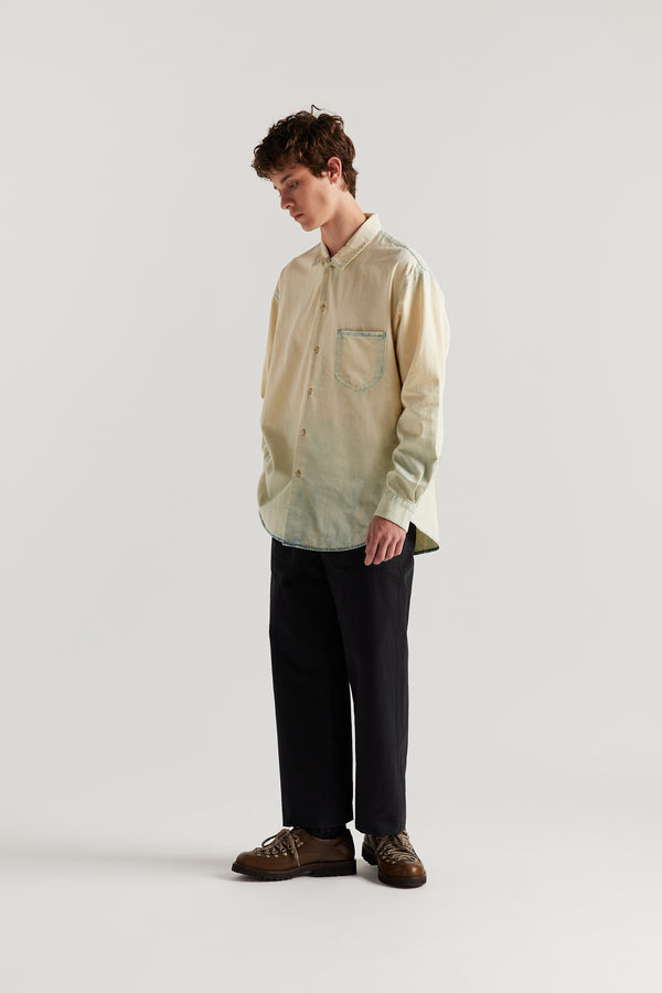 Loose long sleeve Mid-Blue Fade with Ecru Tint denim button-up shirt, front view showing built-in collar, centre button placket, and chest patch pocket with rivet details.