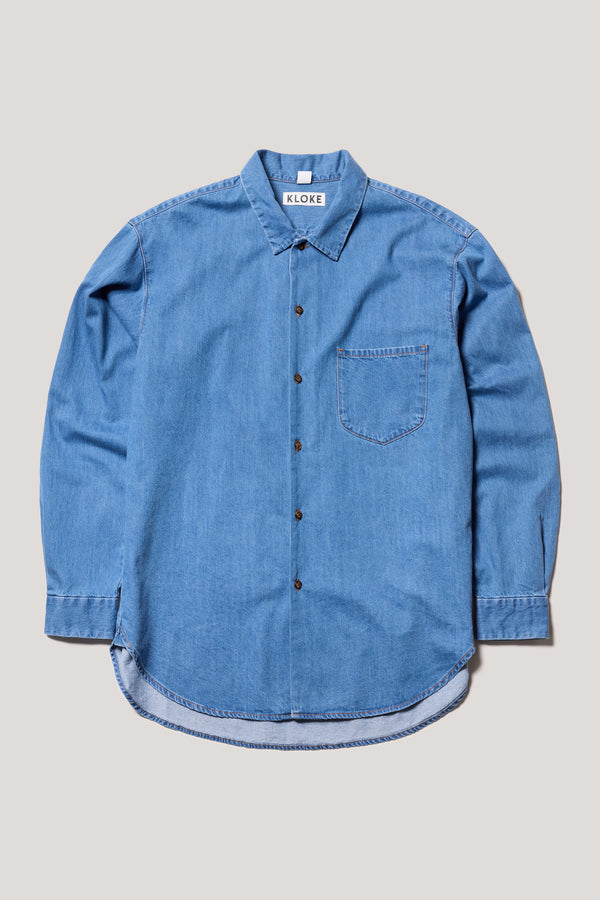 Flat Front Loose long sleeve Finite denim button-up shirt in Mid Wash. Showing built-in collar, centre button placket, and chest patch pocket with rivet details.