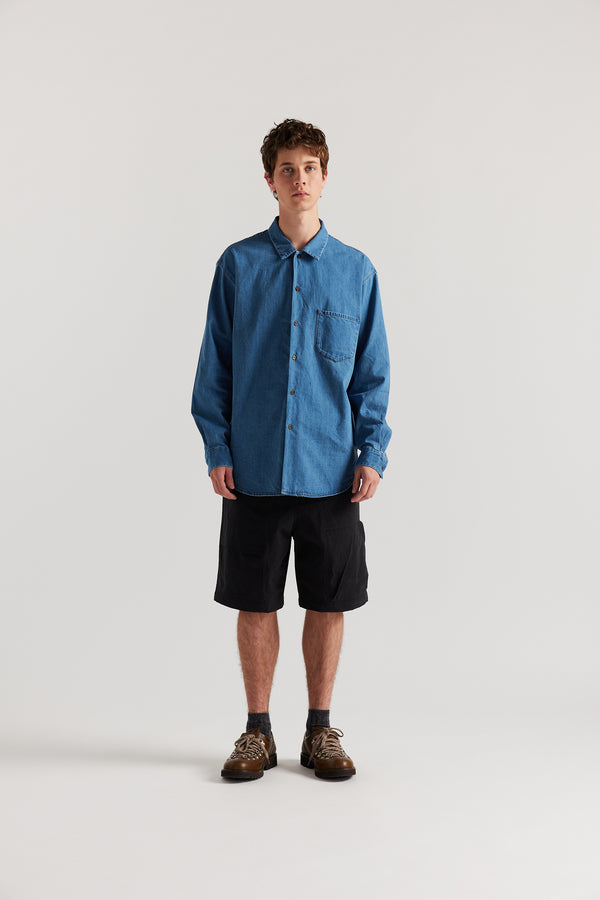 Loose long sleeve Mid Wash  denim button-up shirt, front view showing built-in collar, centre button placket, and chest patch pocket with rivet detail