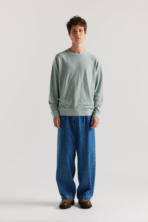 the Mid Wash Impact Denim Pant in lightweight denim, front view showing wide tapered leg, elastic waistband, and traditional front pockets.