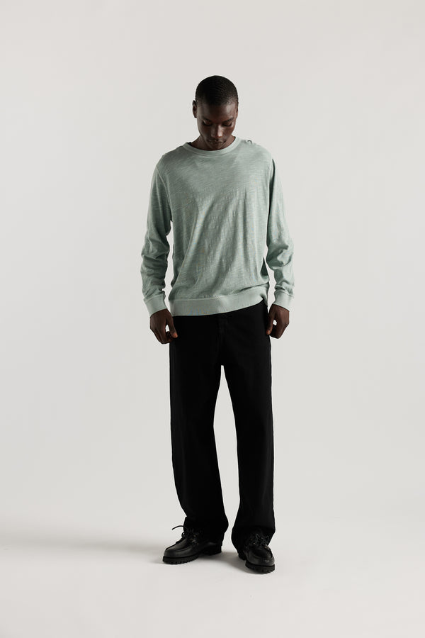 Front view of Ousmane in Black Lenz Pant with straight-leg silhouette, front patch pockets and twin-needle topstitch detail.