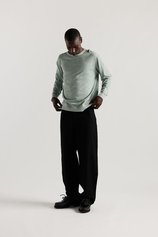 Front view of Ousmane in Black Lenz Pant with straight-leg silhouette, front patch pockets and twin-needle topstitch detail.