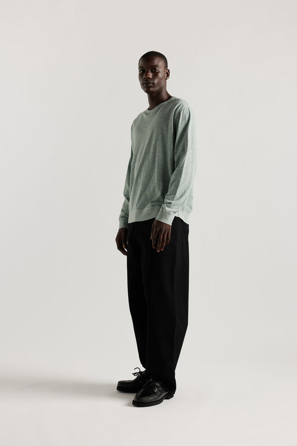 Front view of Ousmane in Black Lenz Pant with straight-leg silhouette, front patch pockets and twin-needle topstitch detail.