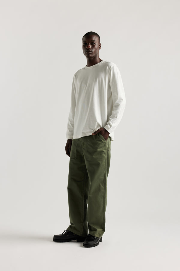 Front view of male model in Olive Lenz Pant with straight-leg silhouette, front patch pockets and twin-needle topstitch detail.