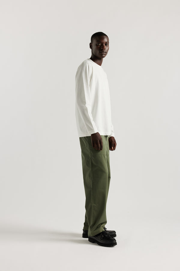 Front view of male model in Olive Lenz Pant with straight-leg silhouette, front patch pockets and twin-needle topstitch detail.