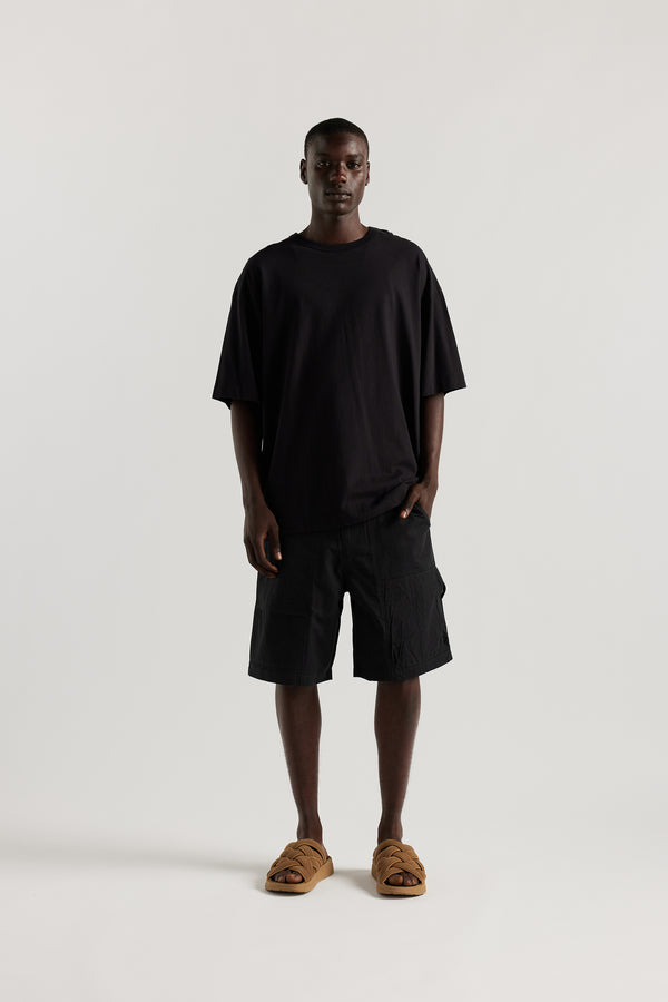 Front view of Ousmane in relaxed fit men’s cotton shorts in black showcasing 3D pocket construction, panel detailing, and structured laid-back design