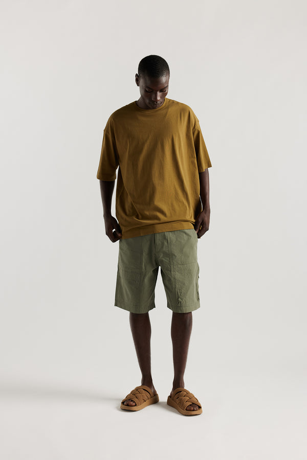 Front view of Ousmane in relaxed fit men’s cotton shorts in Olive green showcasing 3D pocket construction, panel detailing, and structured laid-back design