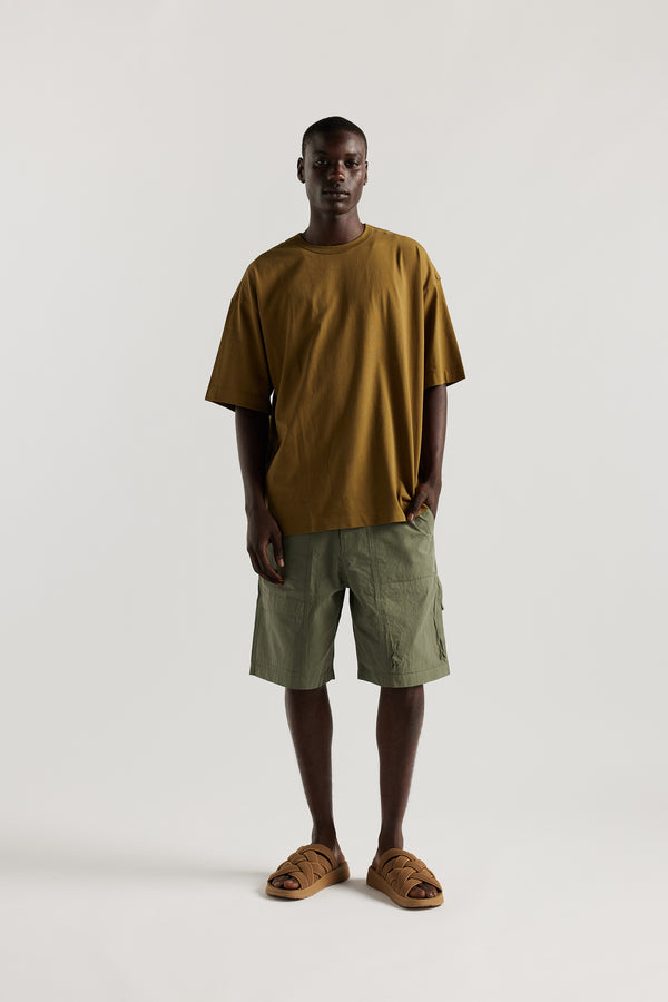 Front view of Ousmane in relaxed fit men’s cotton shorts in Olive green showcasing 3D pocket construction, panel detailing, and structured laid-back design