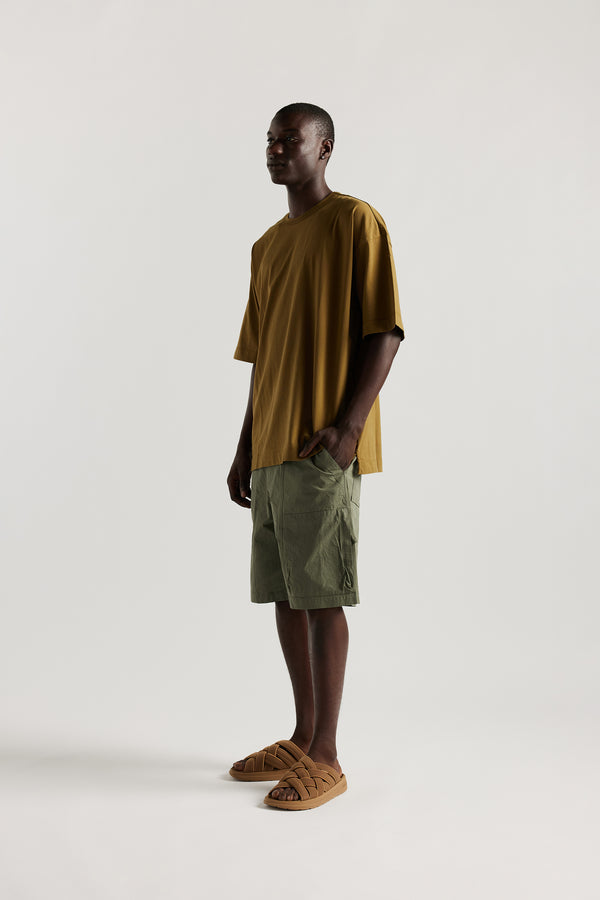 Front view of Ousmane in relaxed fit men’s cotton shorts in Olive green showcasing 3D pocket construction, panel detailing, and structured laid-back design
