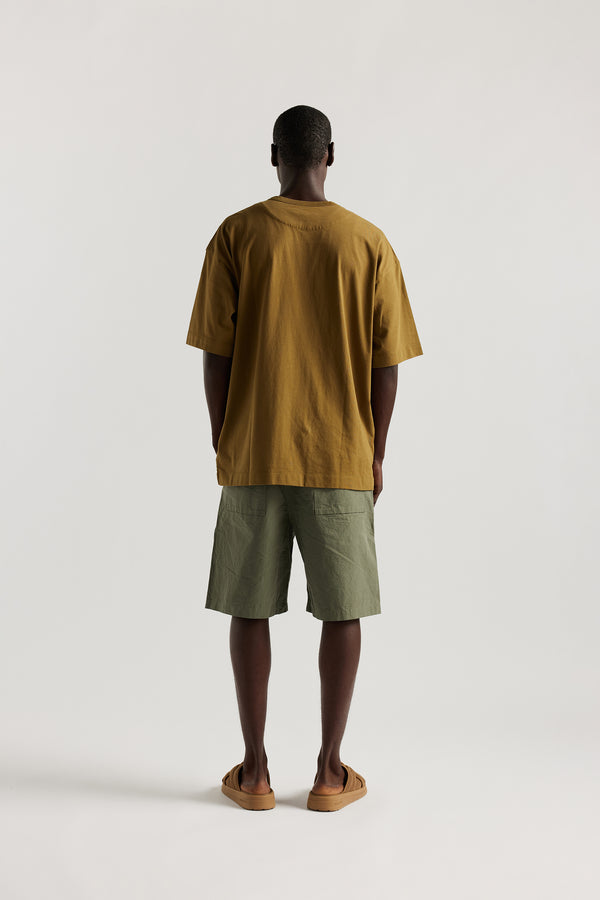 Back view of Ousmane in relaxed fit men’s cotton shorts in Olive green showcasing 3D pocket construction, panel detailing, and structured laid-back design