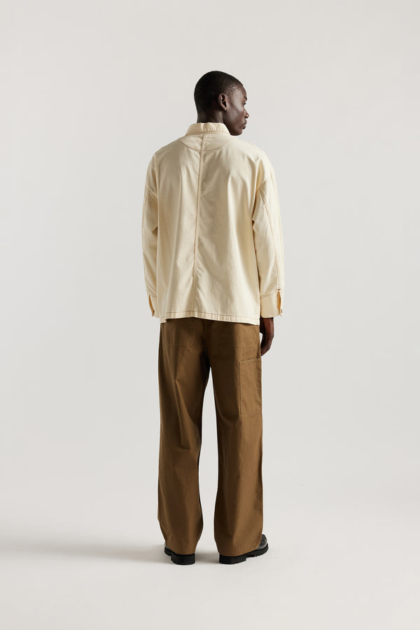 Back of male model wearing the Ecru Protocol Coverall in 100% cotton denim. 