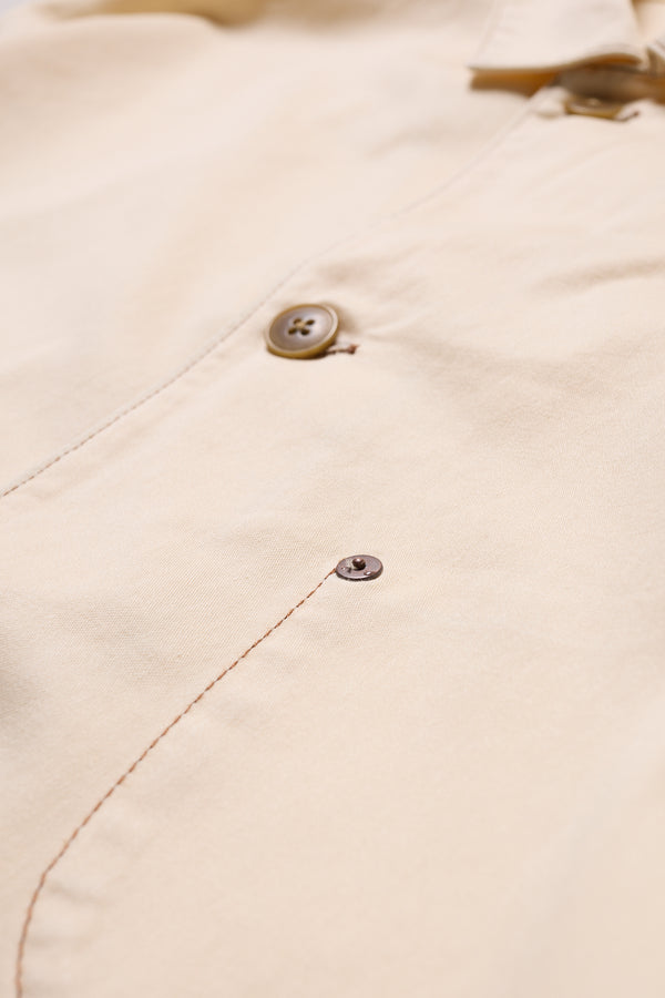 Close-up of Kloke Protocol Coverall in Ecru 100% cotton Denim, highlighting the  internal curved pocket with visible topstitching.
