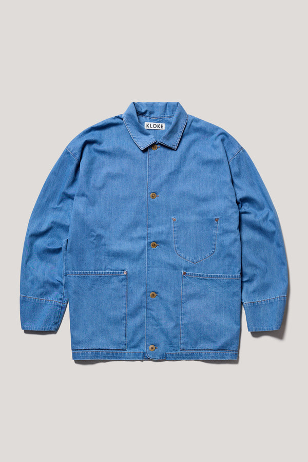 Flat Front of the  Mid Wash Protocol Coverall in light 100% cotton denim, showing multiple patch pockets and built-in collar.
