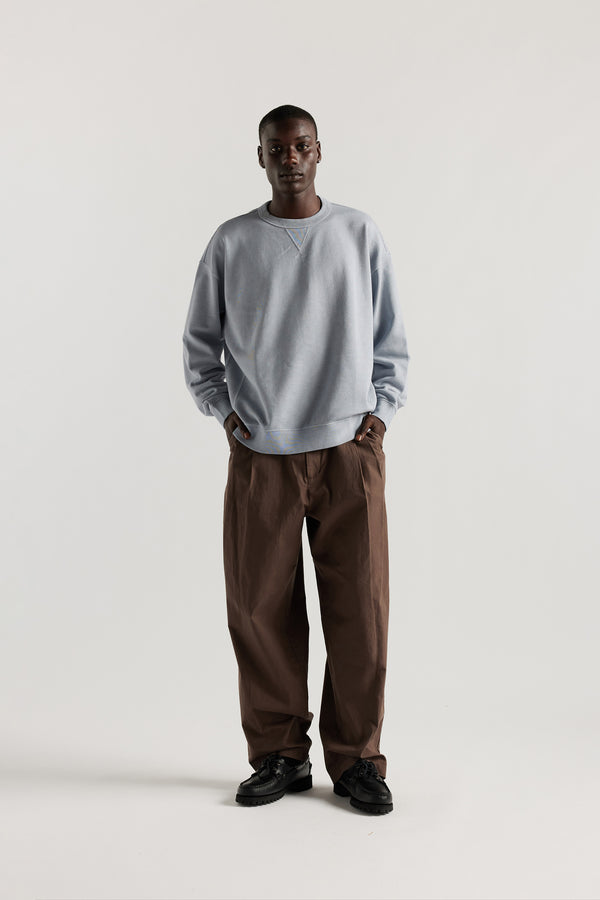 men - Oversized unisex French terry sweater in pigment-dyed finish, shown on model with relaxed dropped shoulders and flatlock seam detailing.