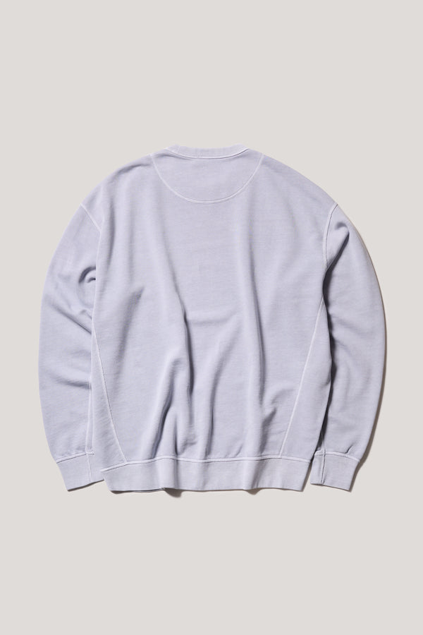 Oversized unisex French terry sweater in pigment-dyed finish, shown on model with relaxed dropped shoulders and flatlock seam detailing.
