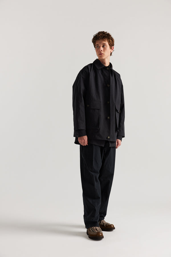 Front view of model in the Jet Black Spectra Jacket ft. short length, buttoned stand collar and 3d Patch Pockets.