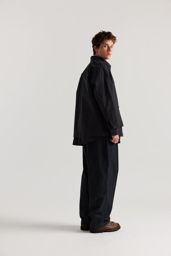 Side Back view of model in the Jet Black Spectra Jacket ft. short length, buttoned stand collar and 3d Patch Pockets.