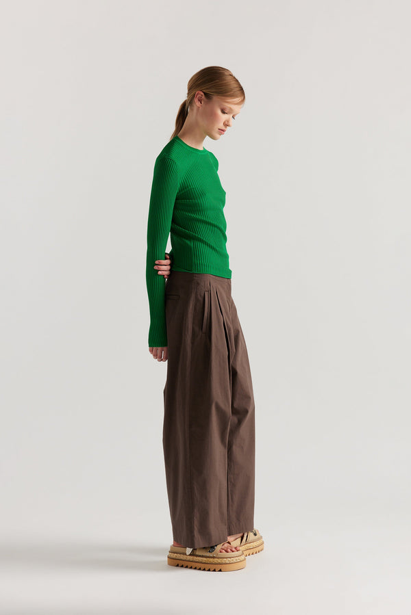 Side of model in Green Verse Knit Tee with subtle drop-stitch texture and fitted long-sleeve silhouette.