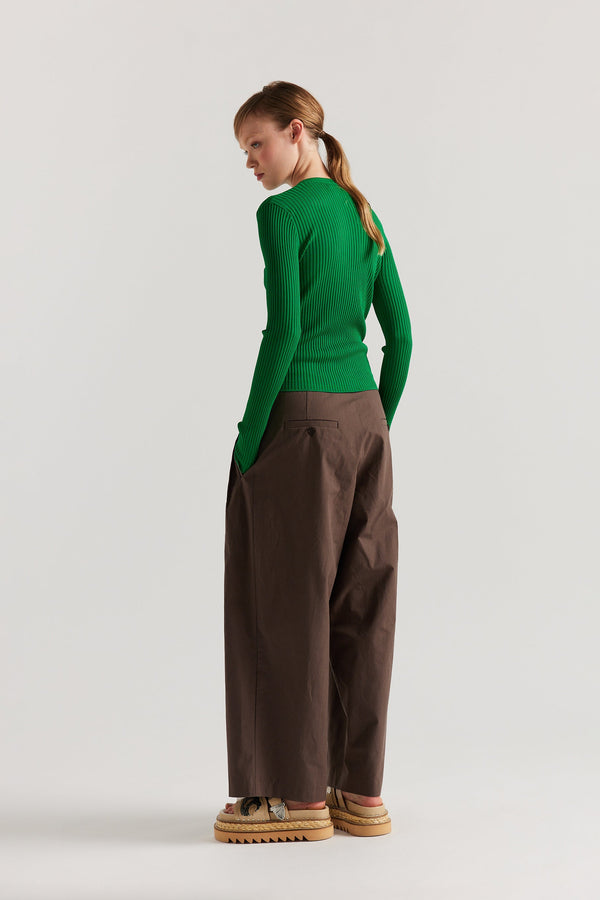 Back of model in Green Verse Knit Tee with subtle drop-stitch texture and fitted long-sleeve silhouette.
