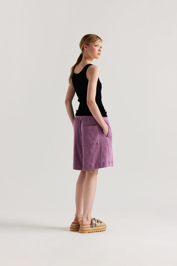 Back of Model wearing the Black Duet Knit Singlet, showing the draped fit and textured knit.