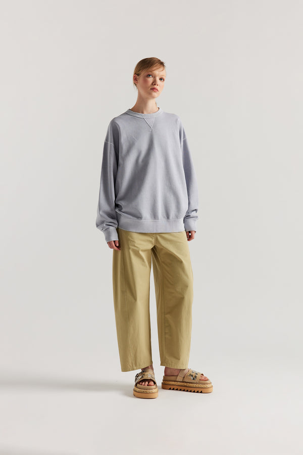 women - Oversized unisex French terry sweater in pigment-dyed finish, shown on model with relaxed dropped shoulders and flatlock seam detailing.
