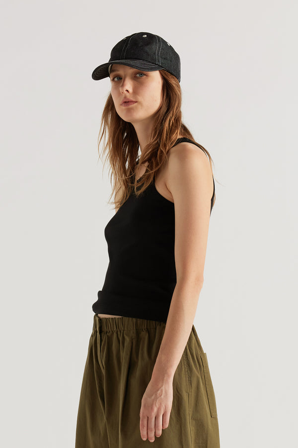 Women - front of female model in Unisex five-panel cap in premium 9oz Japanese dark indigo denim with contrast stitching.